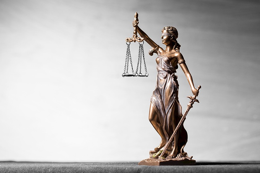 Eine Statur von Justitia wacht über die Einhaltung rechtliche Vorgaben zum energieeffizienten Bauen