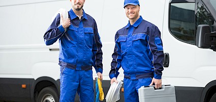 Bauarbeiter vor einem Firmenwagen