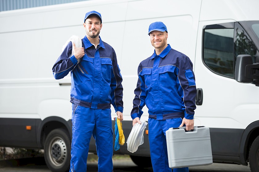 Bauarbeiter vor einem Firmenwagen