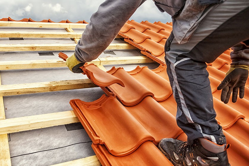 Handwerker erneuert ein Dach für mehr Energieeffizienz