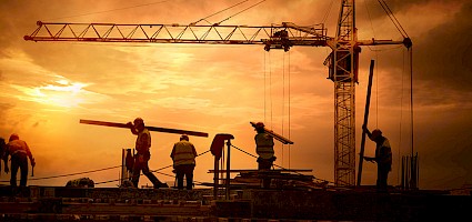 Bauarbeiter auf Baustelle vor Sonnenuntergang